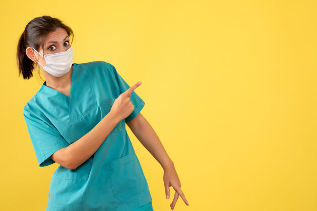 专业前视图黄色背景上穿着医用衬衫和面罩的女医生面具医生衬衫