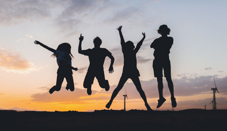 青少年快乐的朋友剪影在日落时跳跃年轻团队太阳