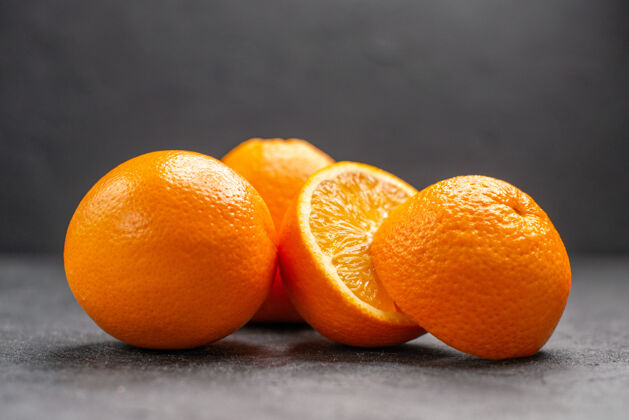可食用水果黑桌子上的整个柠檬和切碎的新鲜柠檬的水平视图多汁柑橘新鲜