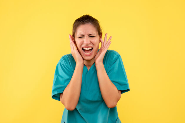 护士前视图：穿着医用衬衫的女医生在黄色背景上磕着耳朵视图成人衬衫