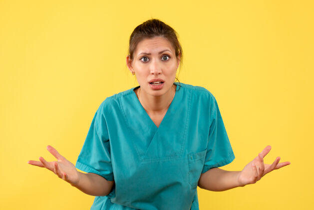 女医生前视图黄色背景上穿着医用衬衫的女医生成人视图护士