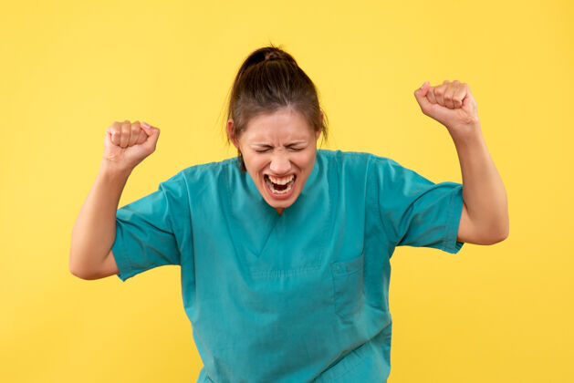 肖像前视图黄色背景上穿着医用衬衫的女医生哑铃健康衬衫