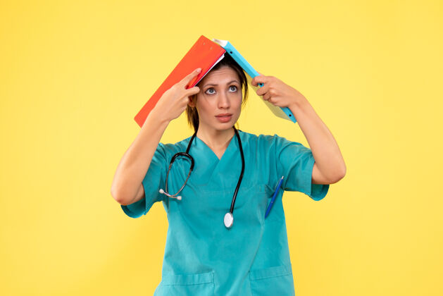 人前视图穿着医用衬衫的女医生拿着黄色背景的笔记前面伞成人