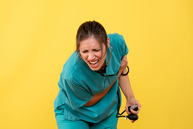 衬衫前视图穿着医用衬衫的女医生正在检查黄色背景上的压力病毒压力人
