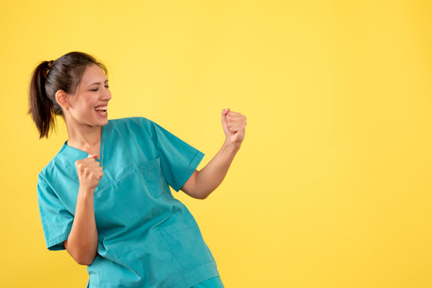 病毒正面图黄色背景上穿着医用衬衫的女医生欢呼雀跃人健康女医生