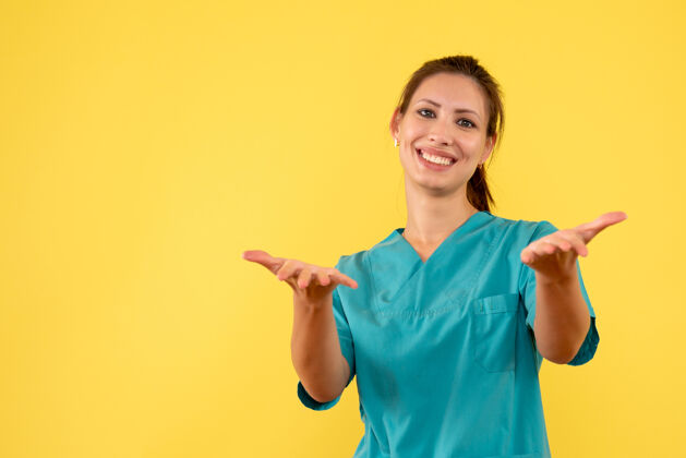 黄色前视图黄色背景上穿着医用衬衫的女医生病毒人物女医生
