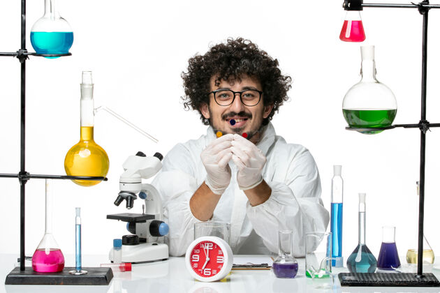 实验室正面图身着特殊套装的年轻男性科学家在白墙上拿着样品实验室科学职业
