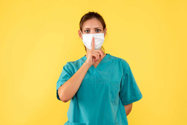 医疗前视图黄色背景上穿着医用衬衫和面罩的女医生女医生衬衫视图