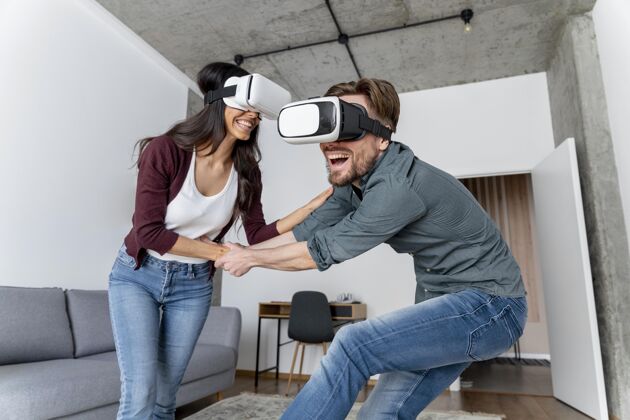 娱乐笑脸女人和男人在家里玩虚拟现实耳机休闲虚拟现实家庭