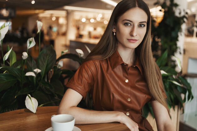 员工在咖啡馆里 优雅迷人的年轻女子倚在咖啡桌上的特写镜头休闲企业家人