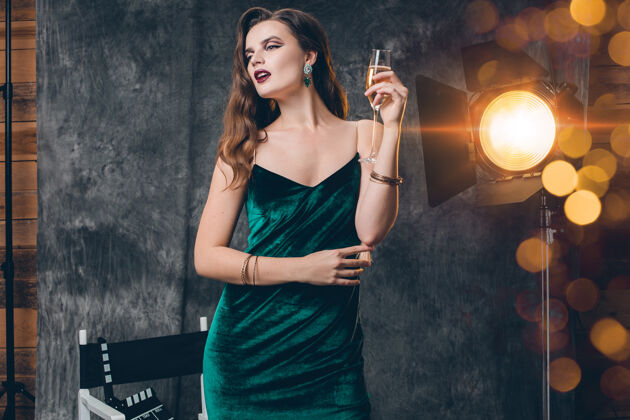 名人年轻时尚性感的女人在电影院后台 用一杯香槟庆祝魅力奢华闪耀
