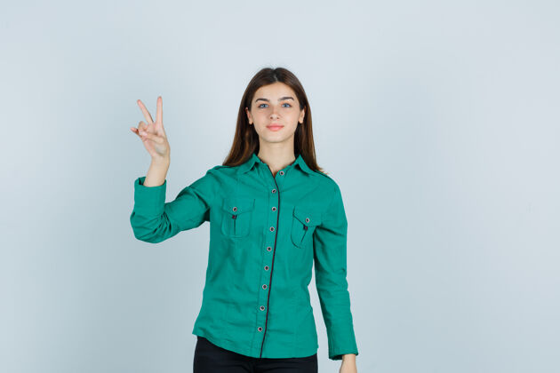胜利身着绿色衬衫的年轻女士展示了胜利的姿态 看起来很自信 正面视图商务女性人物正面