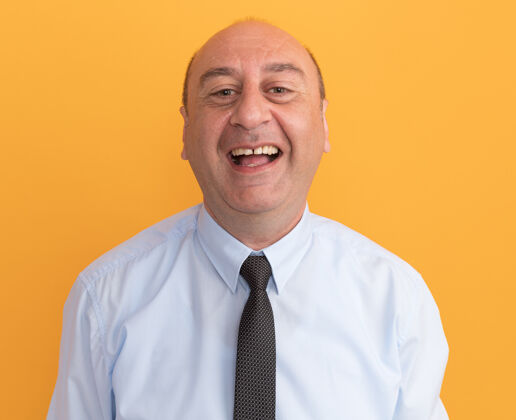笑笑着的中年男子穿着白色t恤 打着领带 隔离在橙色的墙上穿中年领带