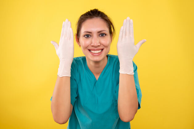 女医生前视图黄色背景上戴白手套的女医生专业肖像黄色