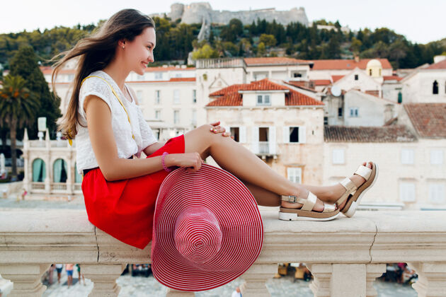 漂亮穿着凉鞋的度假腿上戴着红帽子的漂亮女人春天美丽旅游