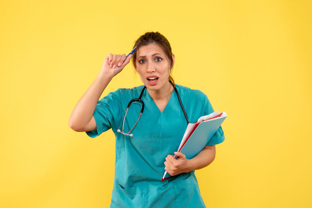 听诊器正面图黄色背景下穿着医用衬衫的女医生拿着分析衬衫女医生病毒
