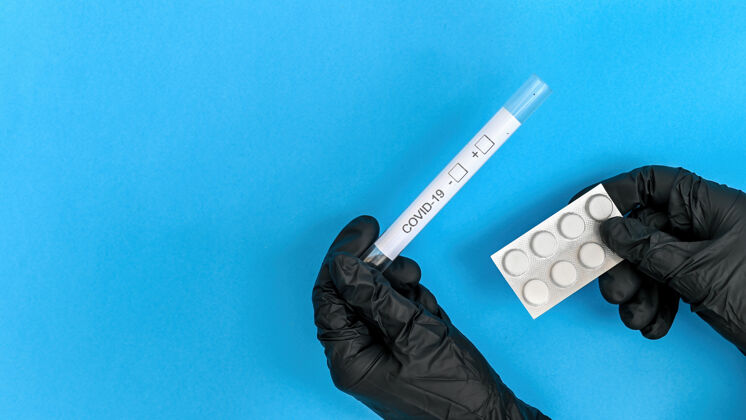 成分手戴黑色医用手套 拿着温度计和药片包蓝色背景顶视图流行病阴性测试
