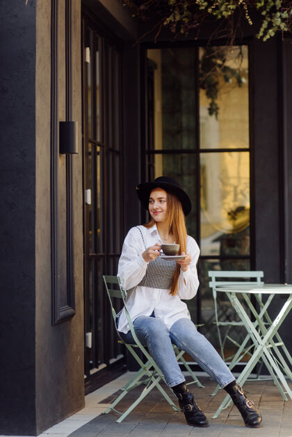 太阳镜在咖啡馆喝咖啡的漂亮女孩华丽街道女士