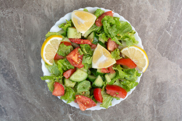 美食蔬菜沙拉加柠檬片放在白色盘子里盘子营养沙拉