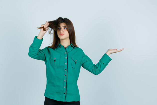 人一幅年轻女性拉着头发 把手掌摊开 穿着绿色衬衫 失望地看着前景色的画像表情一旁人