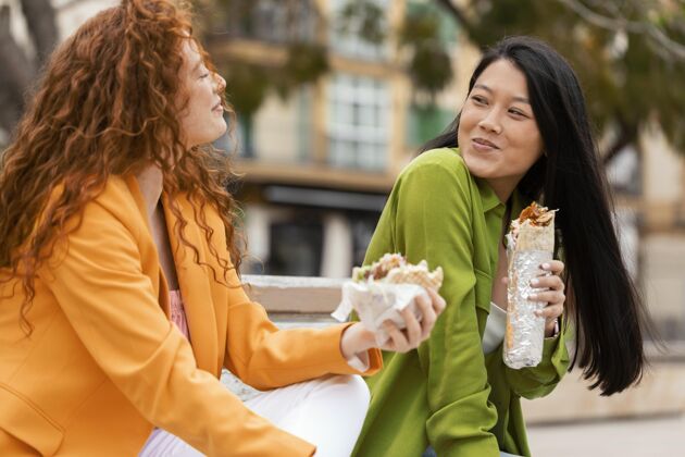 朋友快乐的女人一起吃街头美食饥饿女人美味