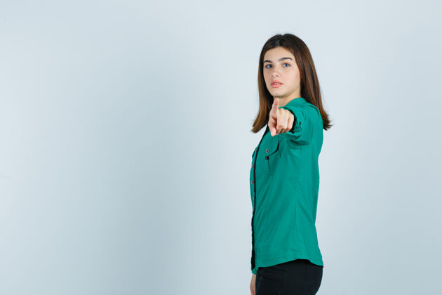 悲伤穿着绿衬衫的年轻女子指着镜头 神情严肃模型成人相机