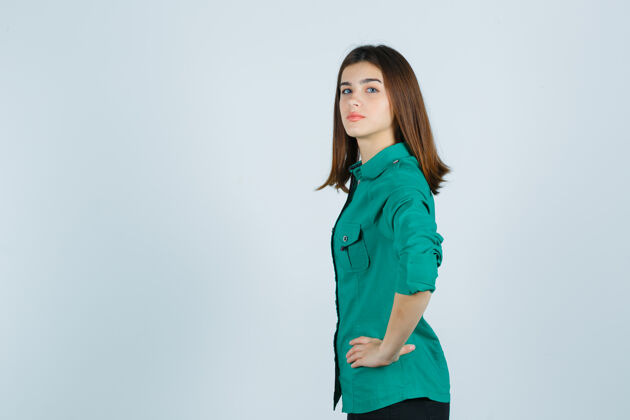 自信年轻漂亮的女士手挽腰 穿着绿衬衫 看起来很自信站立成人腰部