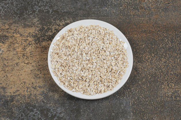 燕麦美味的燕麦片放在白色盘子里农业水平卷燕麦