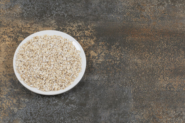 卷燕麦美味的燕麦片放在白色盘子里堆健康种子