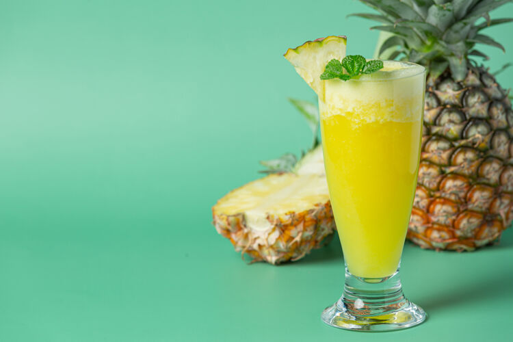 薄荷绿色表面的菠萝汁饮食美味空间