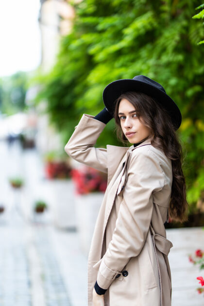漂亮美丽的年轻女子戴着帽子和外套在城里散步模特街道华丽