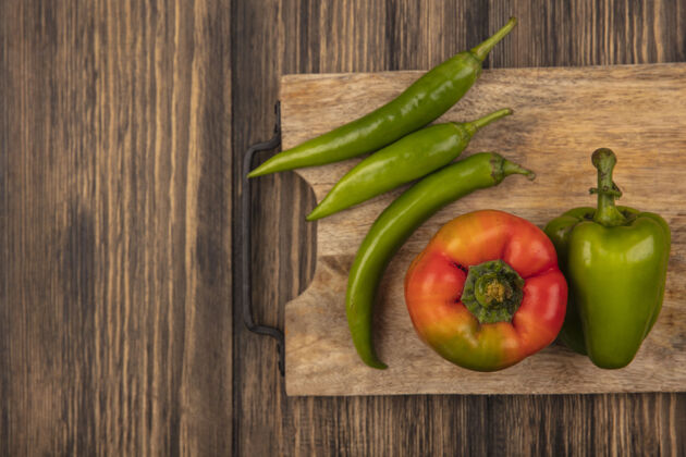 配料健康的红色和绿色辣椒的顶视图在一个木制的厨房板上的木制表面与复制空间饮食胡椒食物