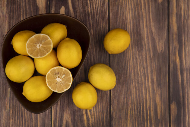 配料顶视图的一半和整个柠檬在一个碗柠檬孤立在一个木制表面与复制空间厨房美味碗