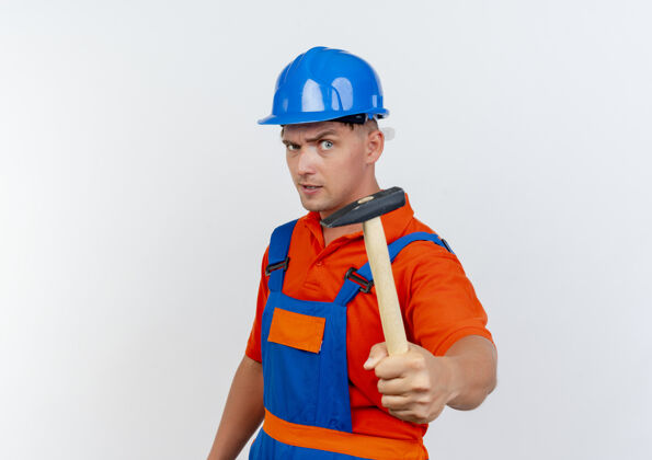 头盔自信的年轻男性建筑工人穿着制服 戴着安全帽 手持铁锤安全信心持有