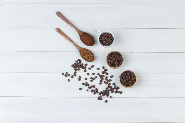 木材一些咖啡豆和磨碎的咖啡放在杯子里 碗放在木制背景上 顶视图阿拉伯语堆新鲜的