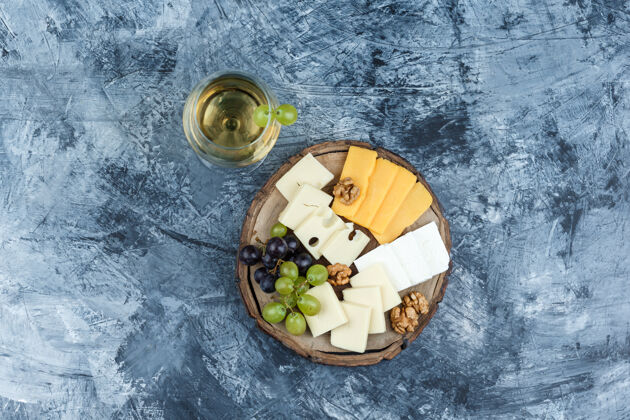 葡萄酒一些葡萄配上一杯葡萄酒 奶酪 胡桃木上的灰泥和木片背景 顶视图核桃葡萄藤饮食