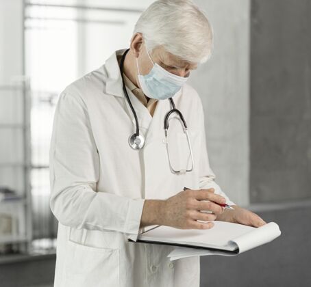 医学戴着医用面罩的医生在检查他的笔记健康医生医疗