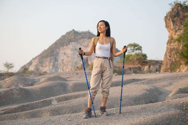 自然适合女性徒步旅行者与背包和杆站在洛基山脉眺望山谷和山峰高峰健康活动