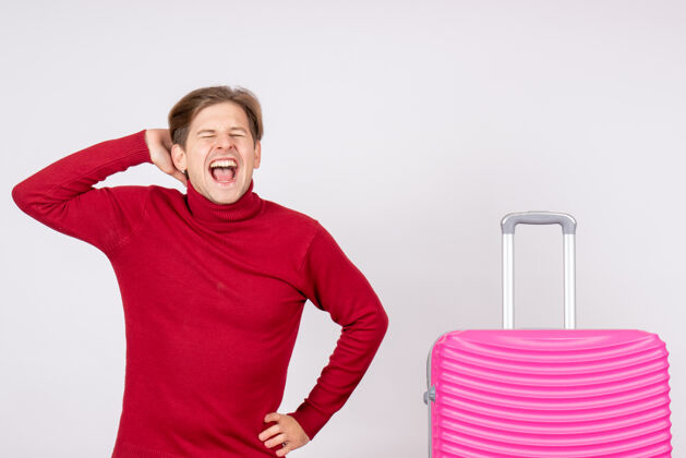 旅行正面图带着粉色包的年轻男性在白色背景上尖叫情感模型旅行航班夏季彩色假期背景尖叫肖像