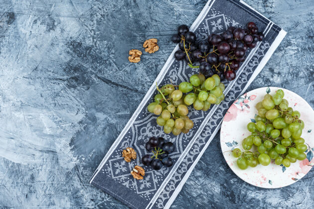 饮食一盘胡桃和葡萄放在垃圾桶和厨房毛巾上顶视图新鲜自然营养