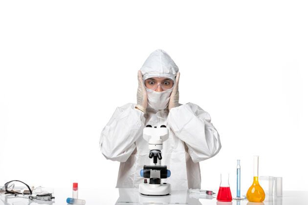 防护罩正面图男医生穿着防护服 戴着口罩 在白色空间上看显微镜大流行防护氧气面罩
