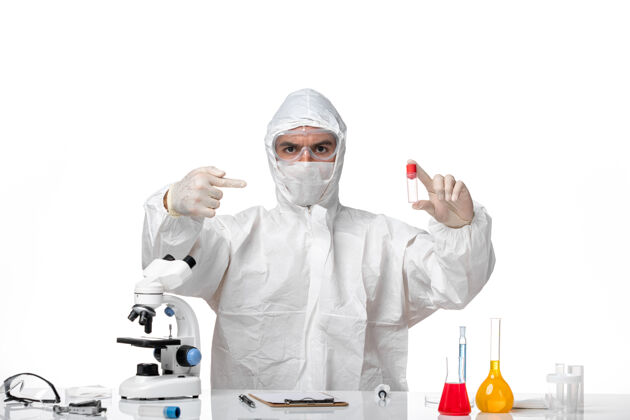 套装正面图：男医生穿着防护服 戴着面罩 因为白色空间上有一个装着柯维德的瓶子医学防护面具