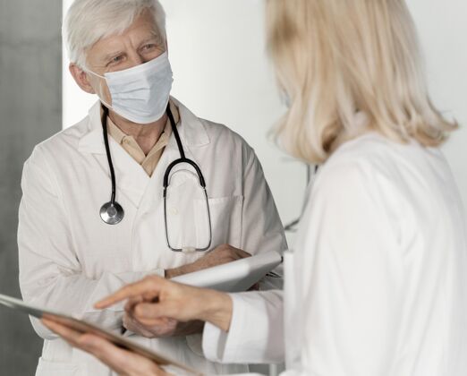 护理戴着医用口罩的医生在说话保健医生实验室