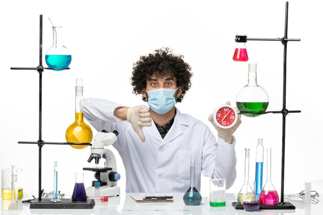 科学正面图：男化学家穿着医疗服 戴着面具 在空白处拿着时钟正面医学手持