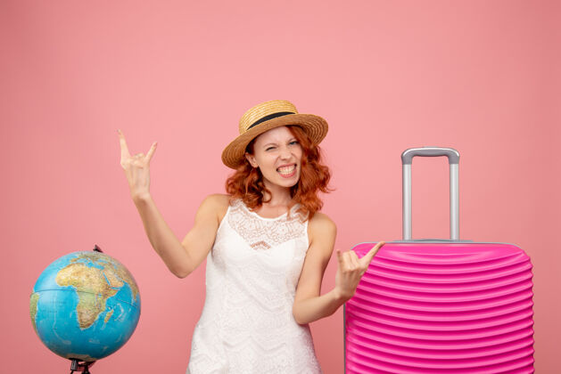 时尚年轻女性游客的正面图 粉红色的墙上挂着粉红色的包快乐模型包
