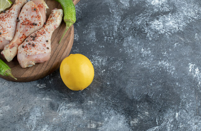 鸡肉新鲜的黄柠檬和生鸡腿放在木板上鸟烹饪准备