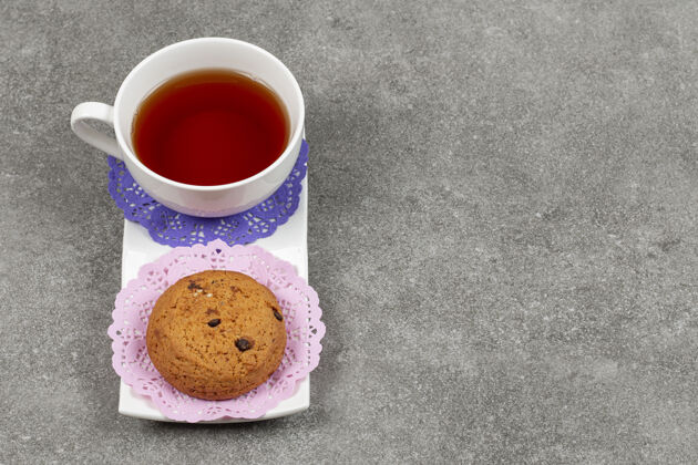 饼干在白碟子上放一杯茶和饼干可可糕点茶