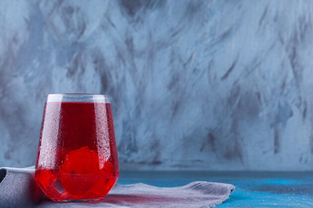 液体一杯果汁和冰块放在麻布表面杯子果汁杯子