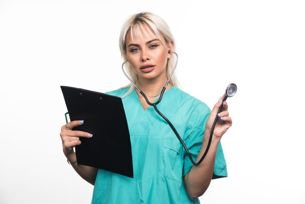站着女医生拿着剪贴板在白色表面上用听诊器女士医疗成人