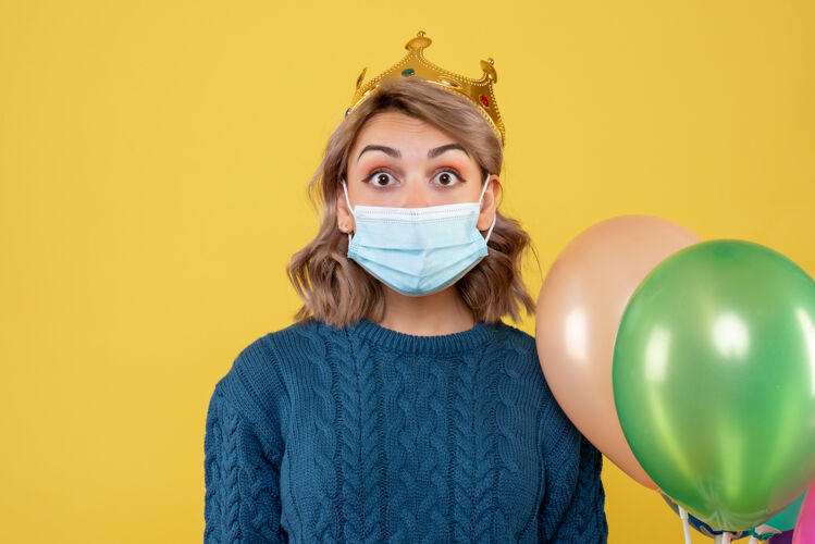 医疗年轻的女性拿着黄色的无菌面具气球医生人们面具